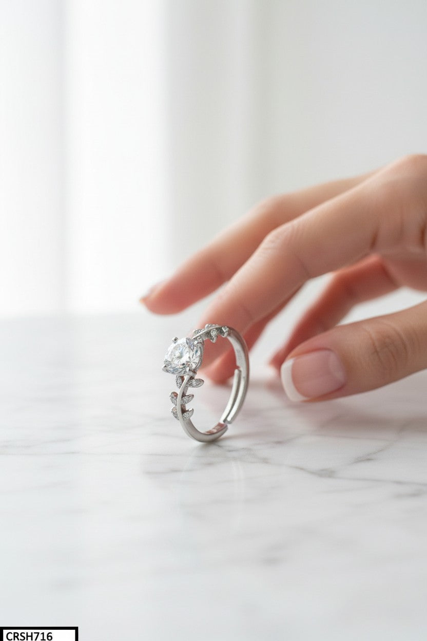 Silver ring with a large diamond on a marble surface