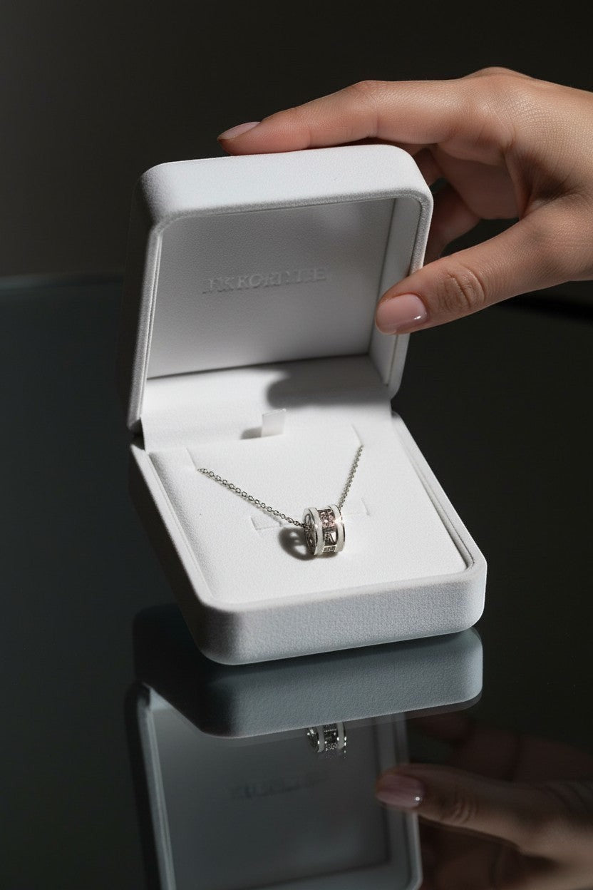 Ownline Galleria sterling silver pendant necklace with cylindrical charm and pink crystal accents in a white jewelry box.