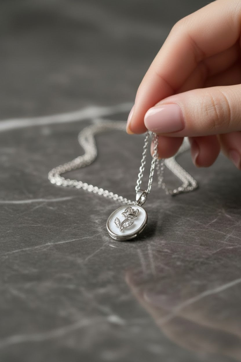 Ownline Galleria sterling silver oval pendant necklace with rose engraving and small clear stones on a delicate chain.